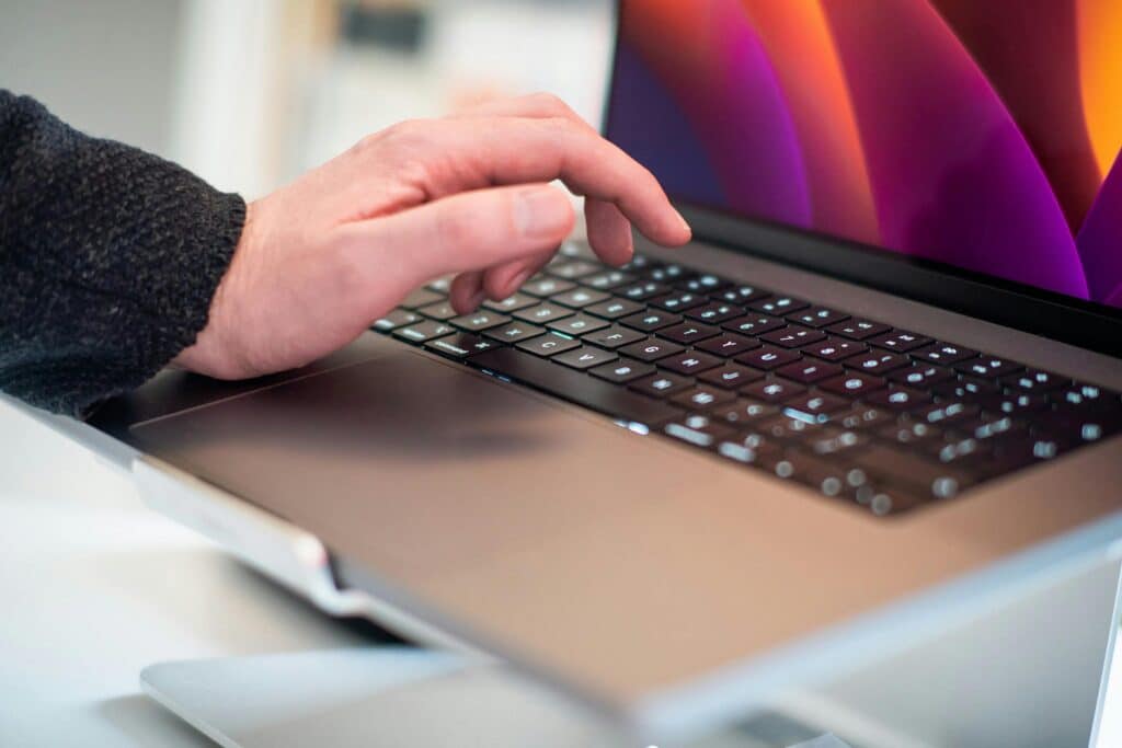 A close-up photo of a person typing on a laptop, highlighting technology usage in daily life.